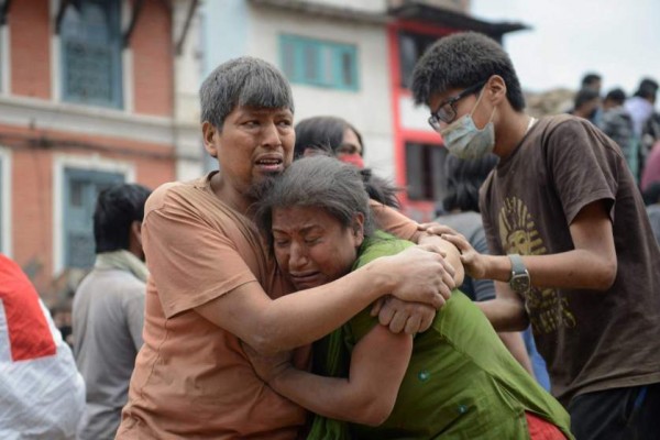 TOPSHOTS A Nepalese man and woman hold each other in Kathmandu's Durbar Square, a UNESCO World Heritage Site that was severely damaged by an earthquake on April 25, 2015. A massive 7.8 magnitude earthquake killed hundreds of people April 25 as it ripped through large parts of Nepal, toppling office blocks and towers in Kathmandu and triggering a deadly avalanche that hit Everest base camp. AFP PHOTO / PRAKASH MATHEMAPRAKASH MATHEMA/AFP/Getty Images