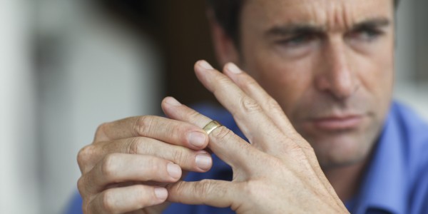 Mature man toying with gold wedding ring on finger