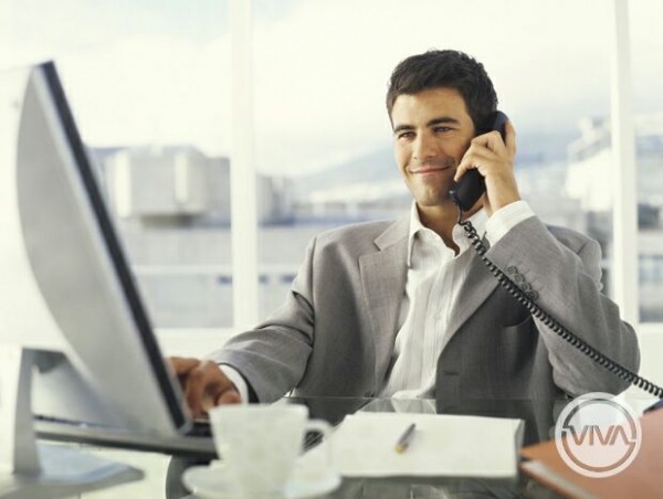 Young businessman using PC and phone