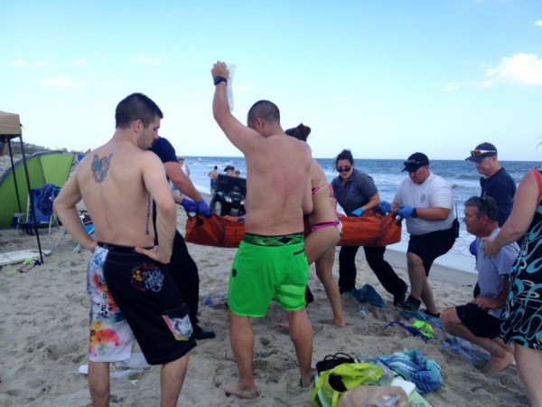 Emergency responders assist a teenage girl at the scene of a shark attack in Oak Island, N.C., Sunday, June 14, 2015. Mayor Betty Wallace of Oak Island, a seaside town bordered to the south by the Atlantic Ocean, said that hours after the teenage girl suffered severe injuries in a shark attack Sunday a teenage boy was also severely injured. (Steve Bouser/The Pilot, Southern Pines, N.C. via AP) MANDATORY CREDIT