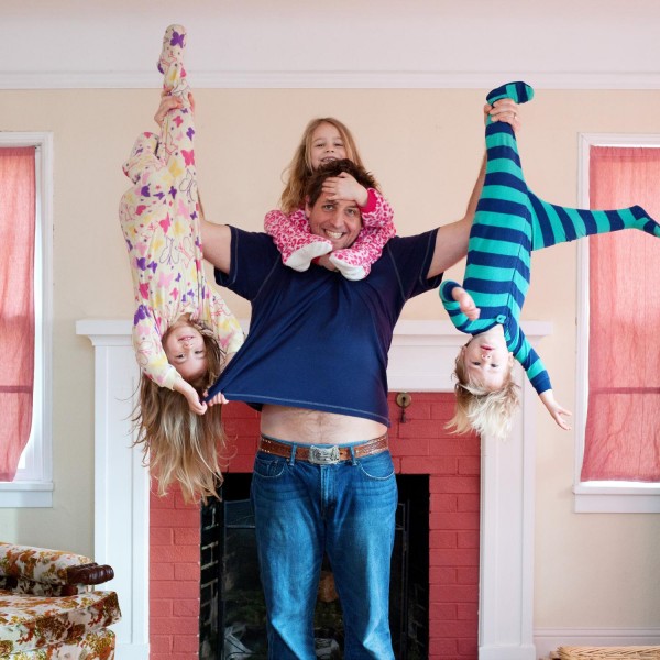 dad-holding-kids-upside-down-paying