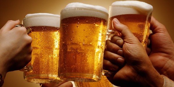 FOUR HANDS MALE AND FEMALE TOAST WITH MUGS OF BEER