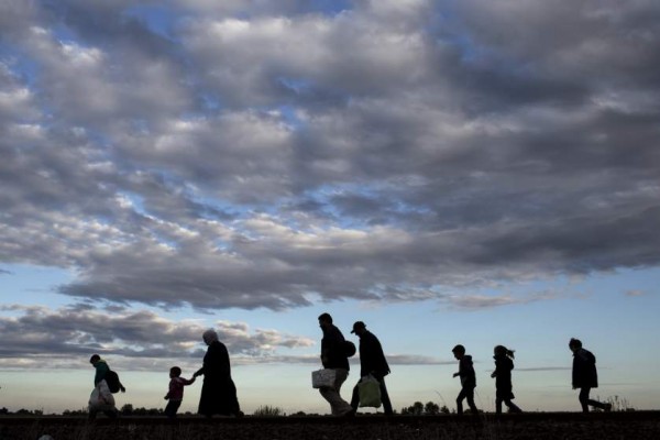 Migrants walk along rail tracks as they arrive to a collection point in the village of Roszke, Hungary, September 6, 2015, after crossing the border from Serbia. Thousands of refugees and migrants streamed into Germany on Sunday, many traveling through Austria from Hungary where they had been stranded against their will for days, while European Union governments argue over how to respond. REUTERS/Marko Djurica      TPX IMAGES OF THE DAY