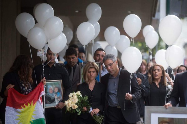 Tima Kurdi, center left, aunt of late brothers Alan and Ghalib Kurdi, and her husband Rocco Logozzo walk to the waterfront to release balloons in memory of the boys after a memorial service in Vancouver, British Columbia, Canada on Saturday, Sept. 5, 2015. The body of 3-year-old Alan was found on a Turkish beach after the small rubber boat he, his 5-year-old brother and their mother, Rehanna, were in capsized during a voyage from Turkey to Greece. (Darryl Dyck/The Canadian Press via AP) MANDATORY CREDIT