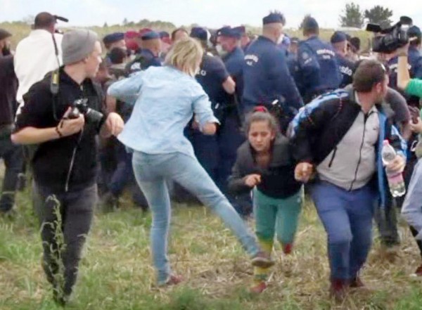 This video grab made on September 9, 2015 shows a Hungarian TV camerawoman kicking a child as she run with other migrants from a police line during disturbances at Roszke, southern Hungary. After the footage appeared, the camerawomen was fired on September 8 by N1TV, an internet-based TV station close to Hungary's far-right Jobbik party. The woman, later named as Petra Laszlo, can be seen tripping a man sprinting with a child in his arms, and kicking another running child in two separate incidents. The scenes took place as hundreds of migrants broke through a police line at a collection point close to the Serbian border where thousands have been crossing over each day for the past month.     AFP PHOTO / INDEX.HU        (Photo credit should read -/AFP/Getty Images)