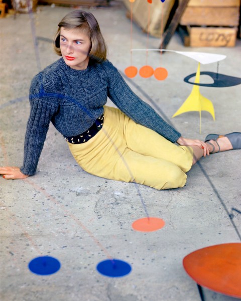 1947, Connecticut, USA --- A fashion model poses in suede "pedal pushers" and a sweater behind one of Alexander Calder's mobiles at the artist's studio. --- Image by © Genevieve Naylor/Corbis