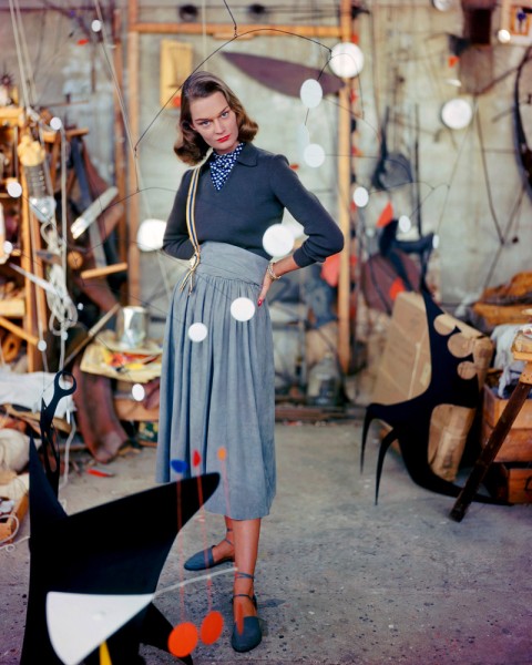 1948, Connecticut, USA --- A woman models a gray suede skirt in the studio of artist Alexander Calder, strolling among his mobiles. --- Image by © Genevieve Naylor/Corbis